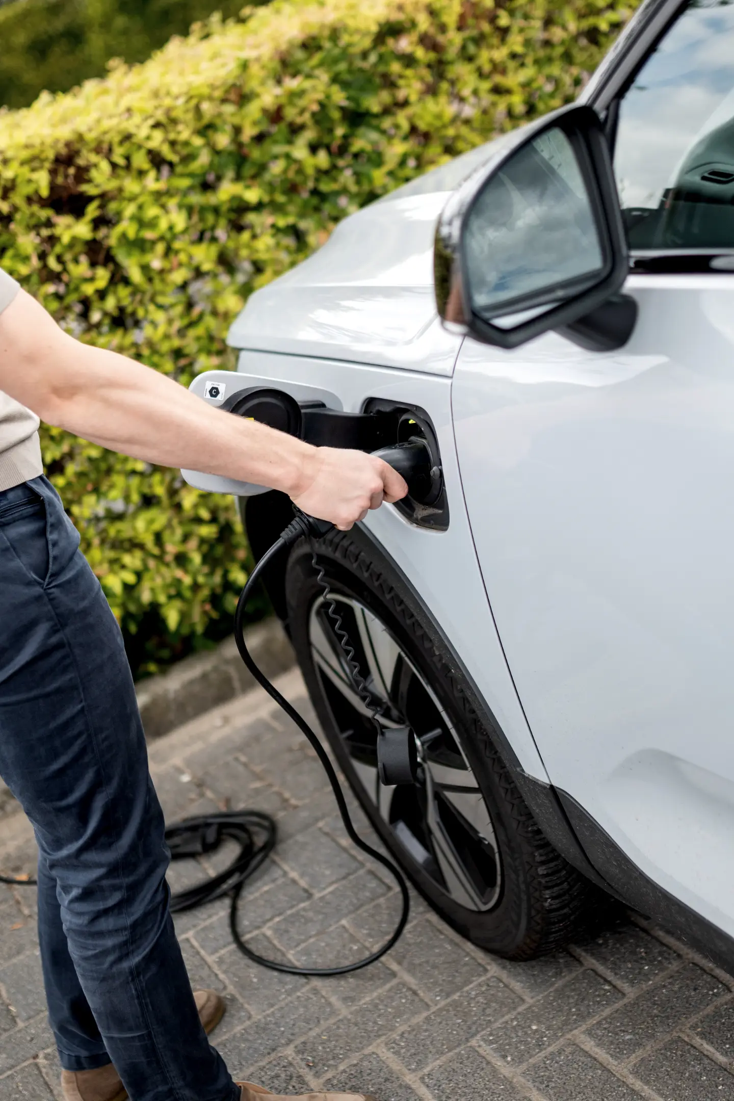 Laadstekker wordt in een elektrische auto gestoken bij een woning