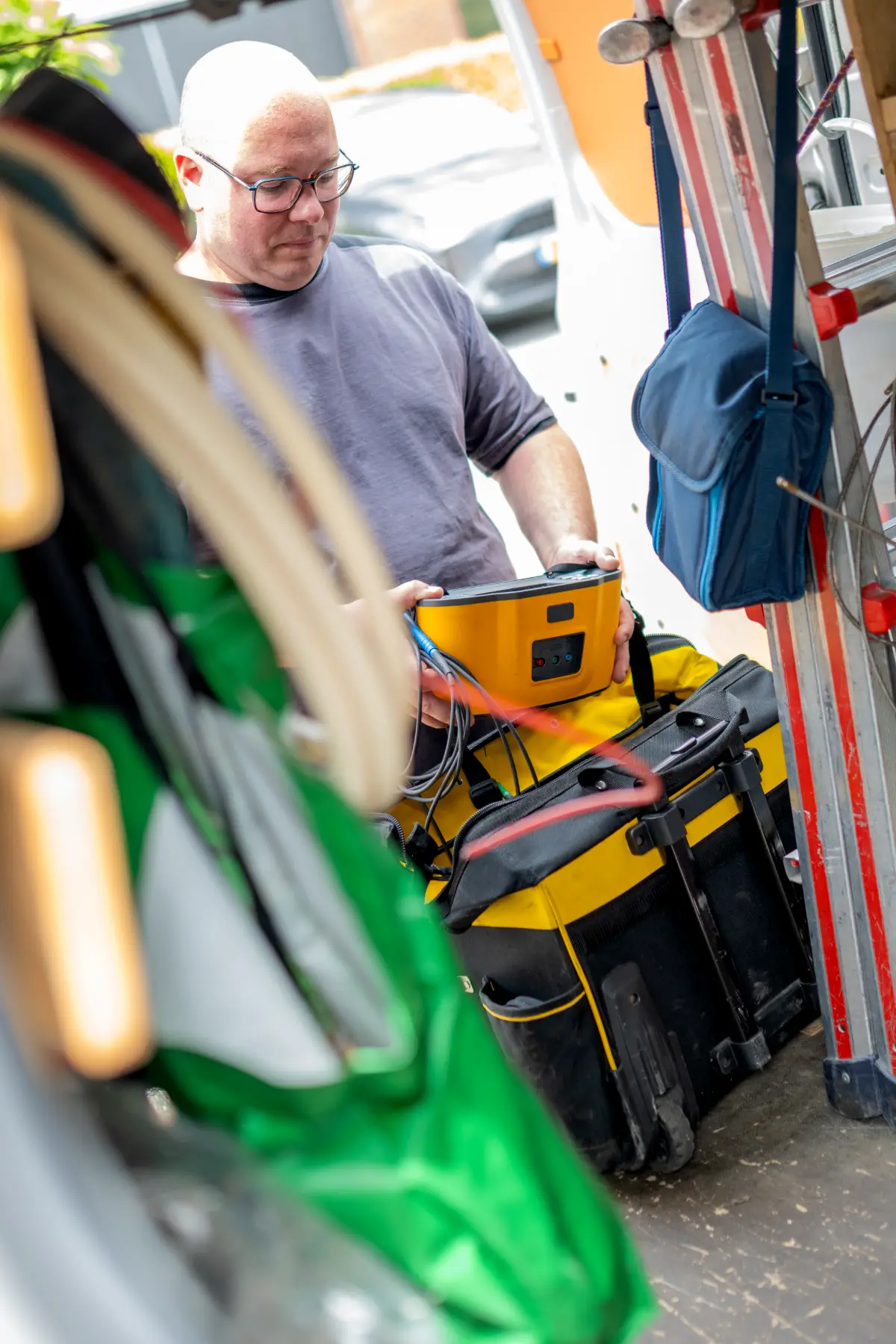 Monteur pakt zijn meetinstrument uit de bus voor een installatie