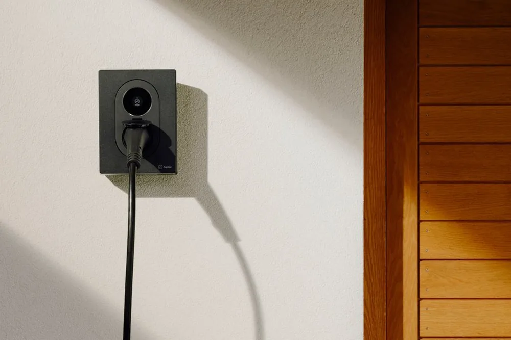 Zaptec Go 2 laadpaal aan de gevel van een woning, met de laadkabel erin